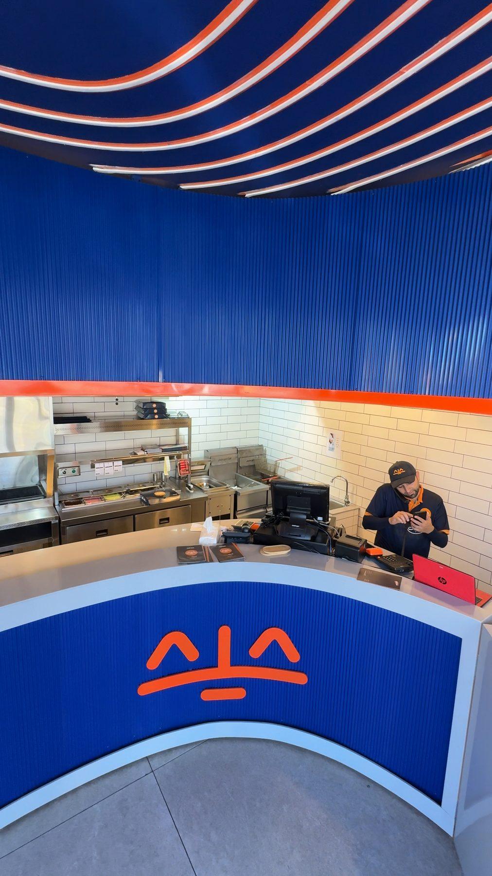 The counter front and the kitchen behind it.