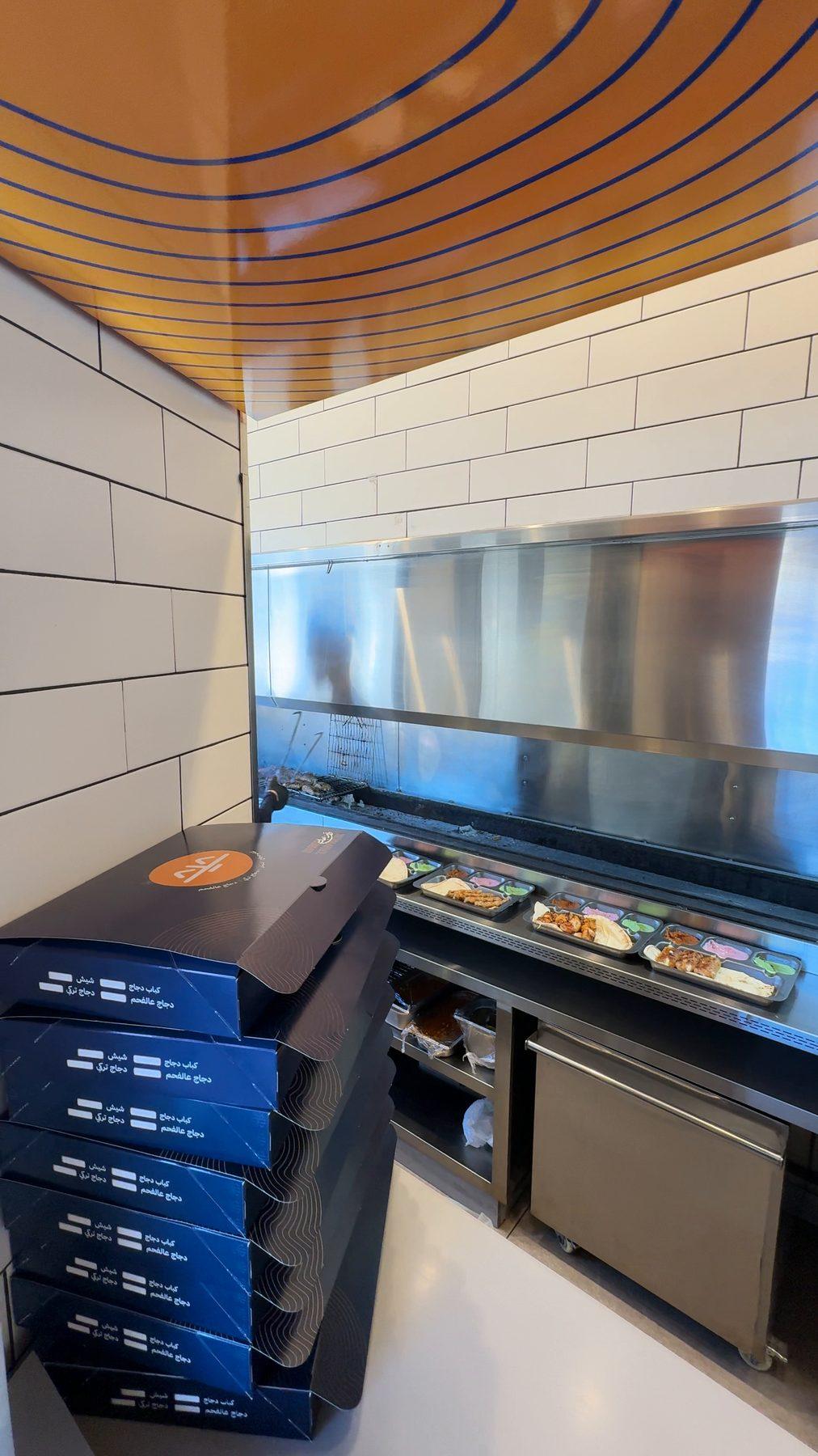 The kitchen line under the wooden ceiling.