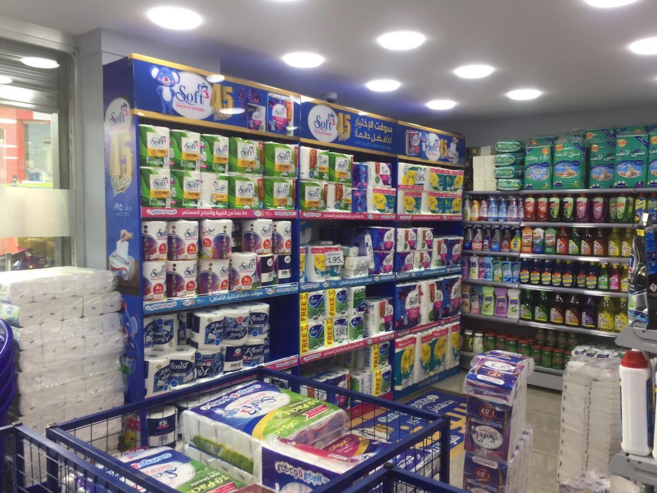 Blue branded shelving stocked with products along a store aisle