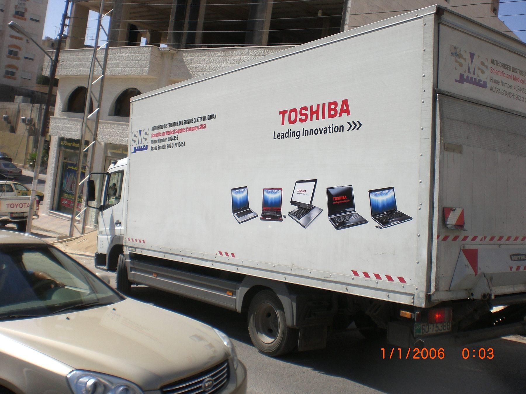 White box truck with Toshiba wordmark and laptop images