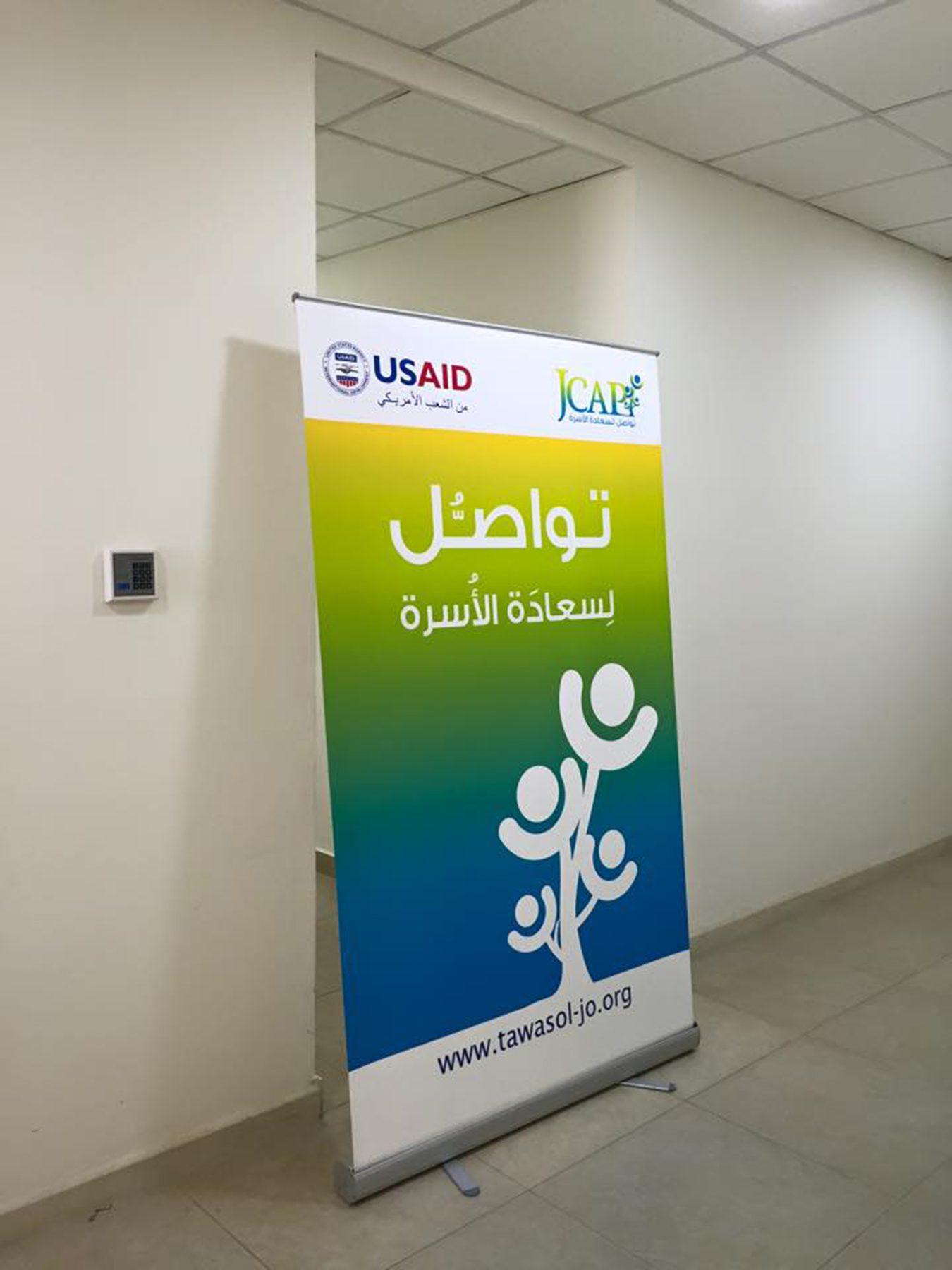 Roll-up banner with Arabic and English text and logos