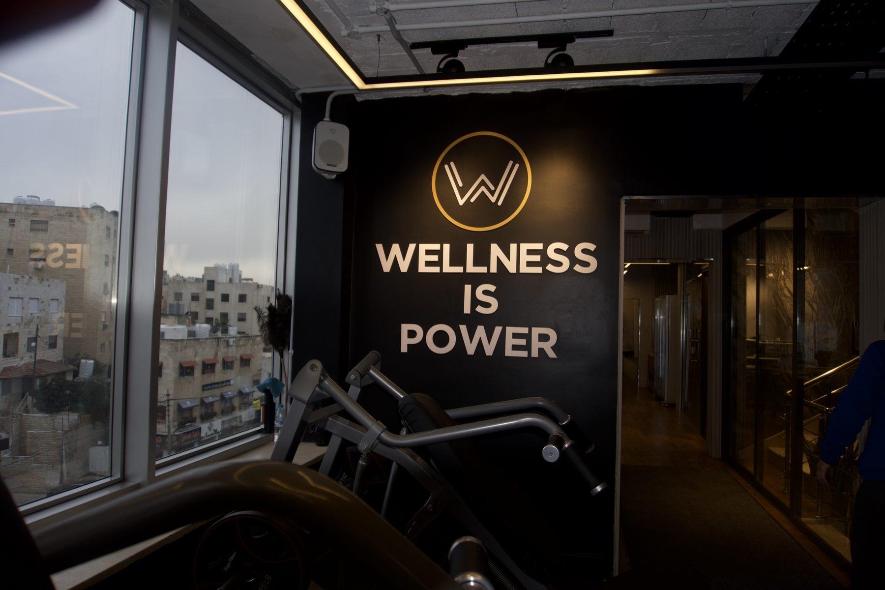 Tagline lettering with emblem beside a staircase and glass door