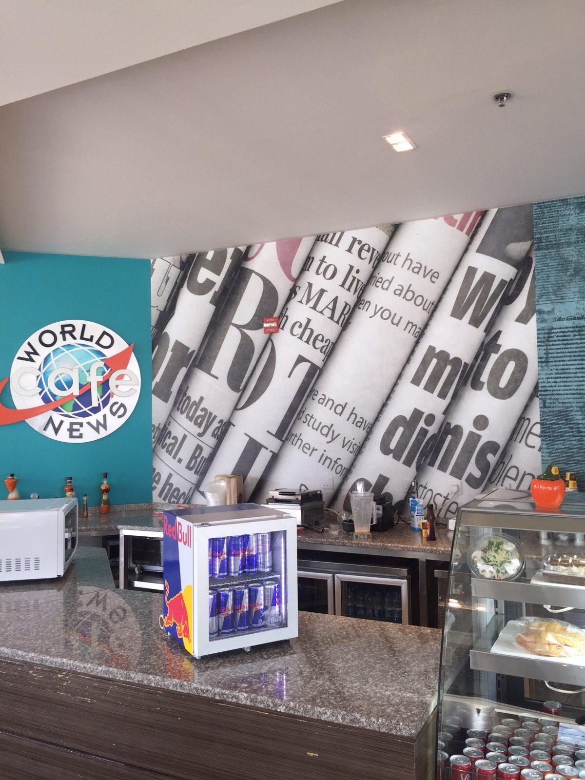 Newspaper-style printed wall graphic above a cafe counter
