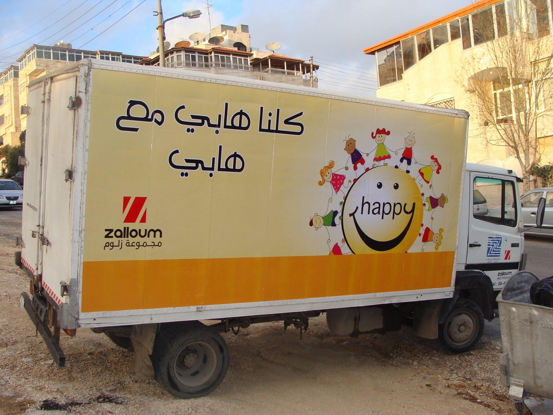 Yellow box truck with character graphic, rear three-quarter view