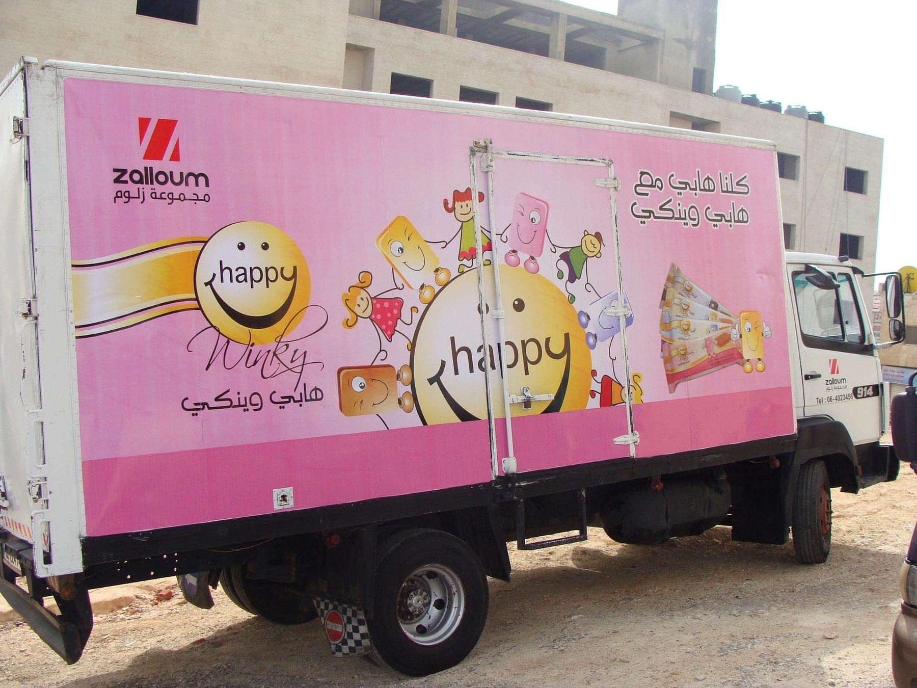 Pink box truck with large character graphic, front three-quarter view