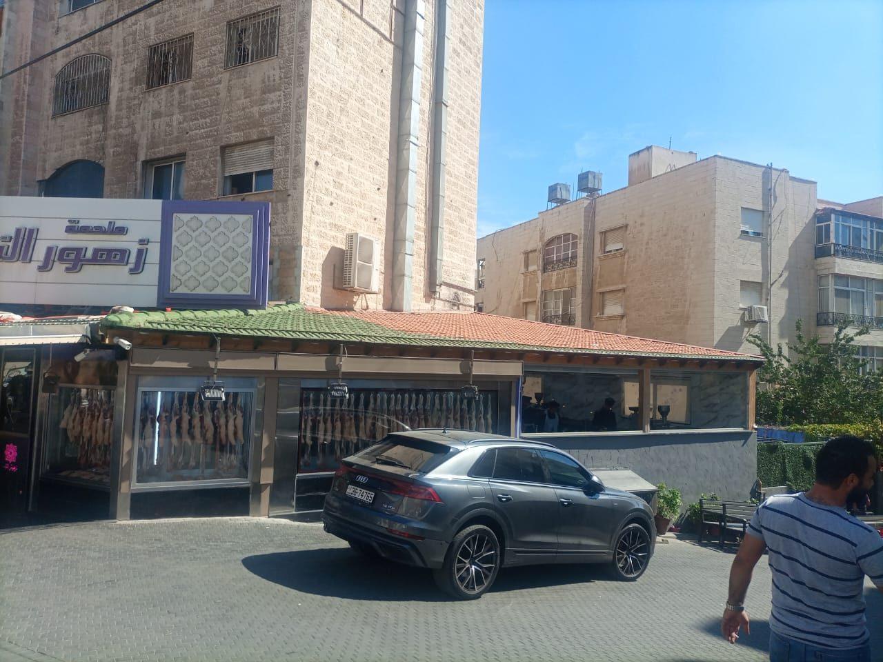 Long Arabic fascia on a stone building above a kiosk, in daylight