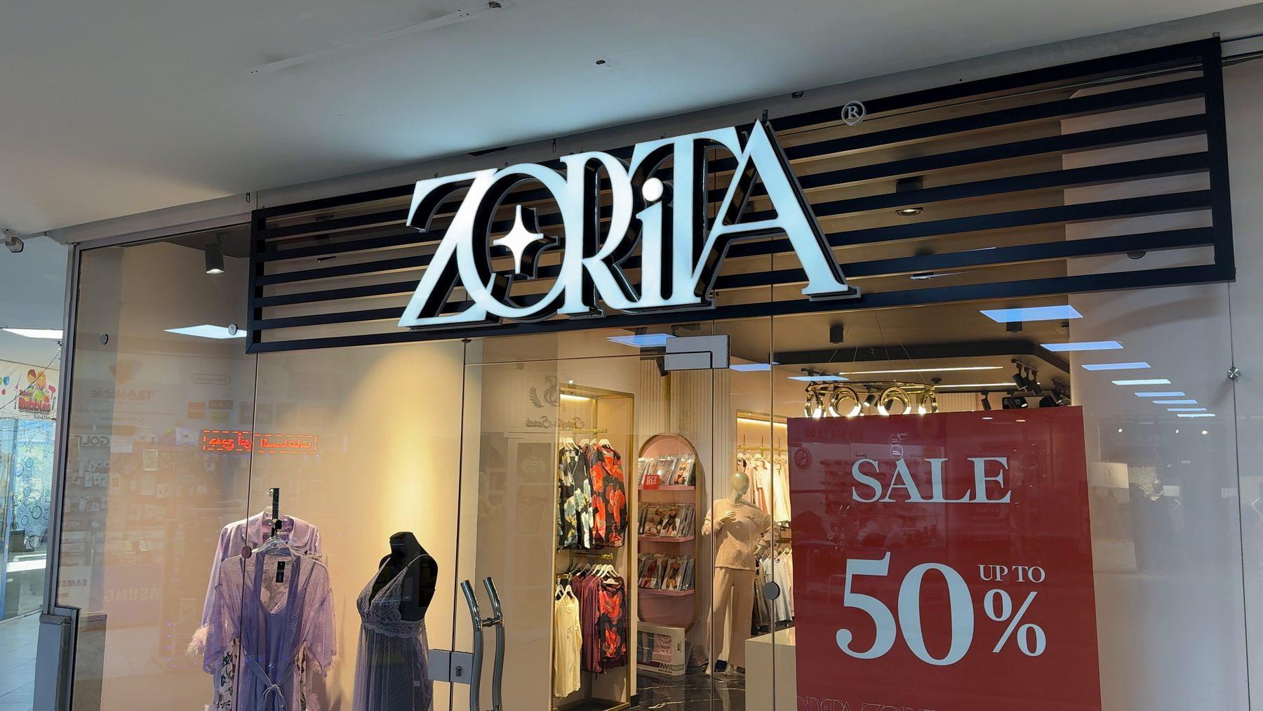 The Khalda store: illuminated logo over the slatted fascia.