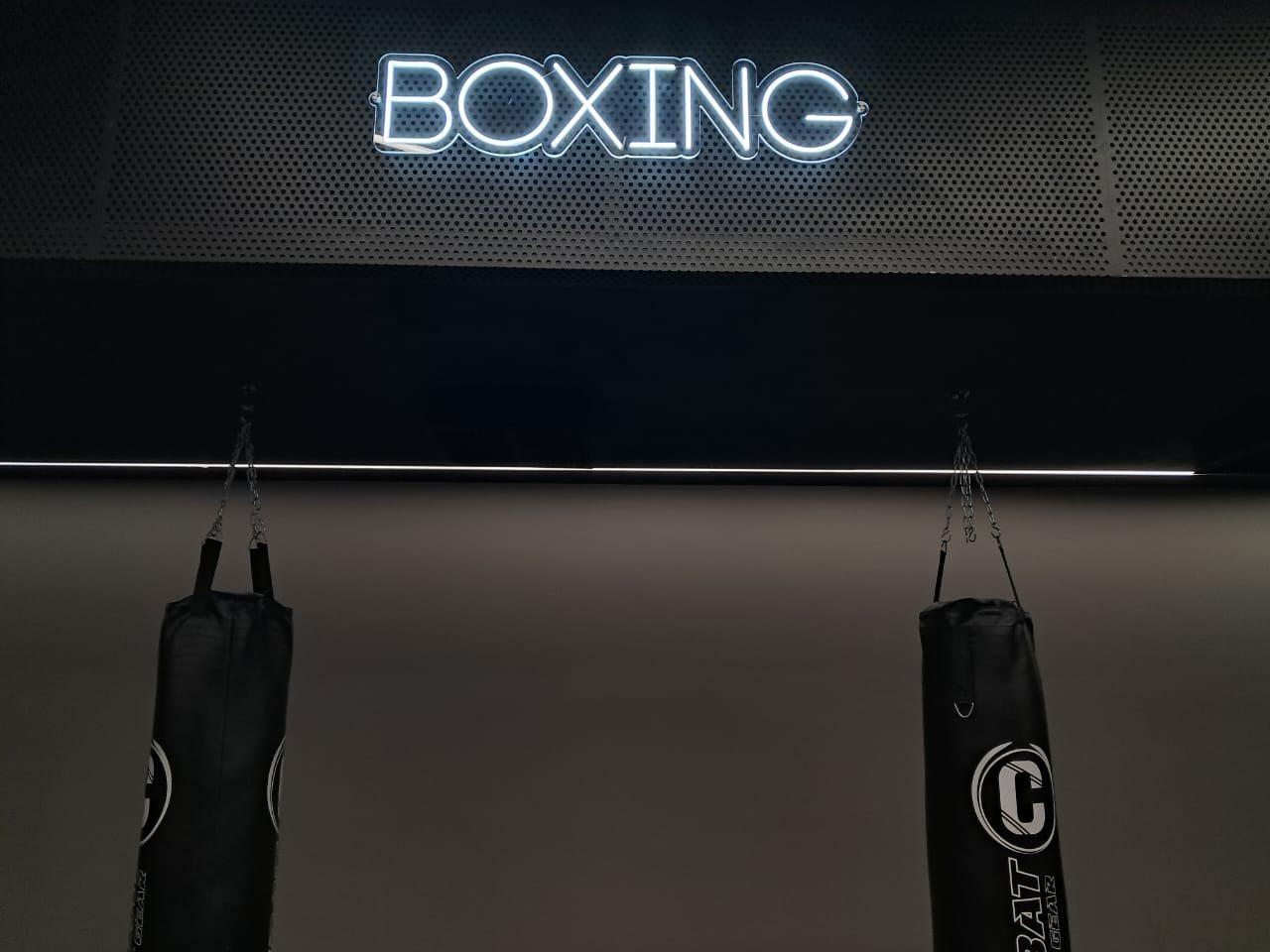Neon lettering on a perforated panel in a gym