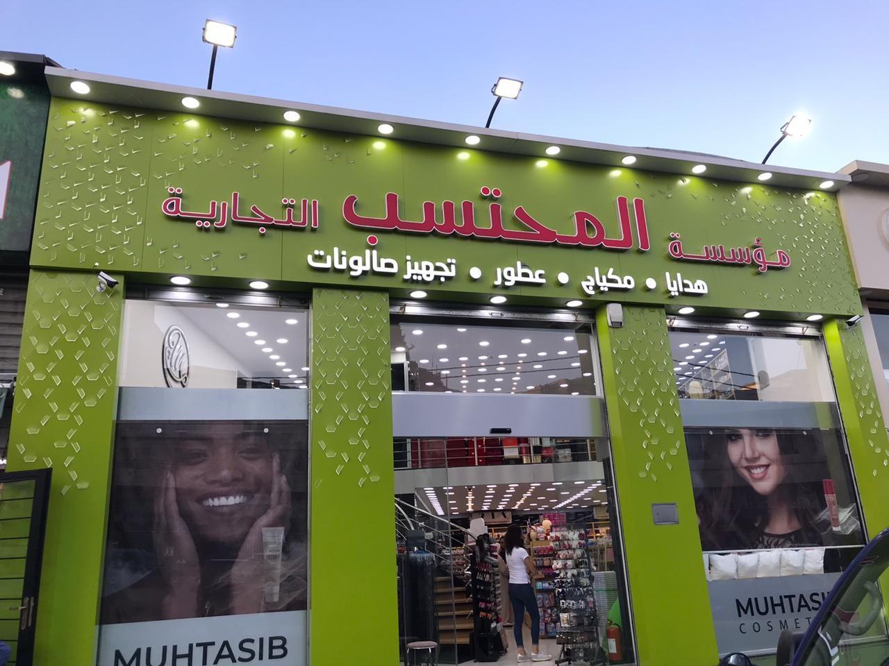 Green fascia with Arabic and English lettering and printed window graphics