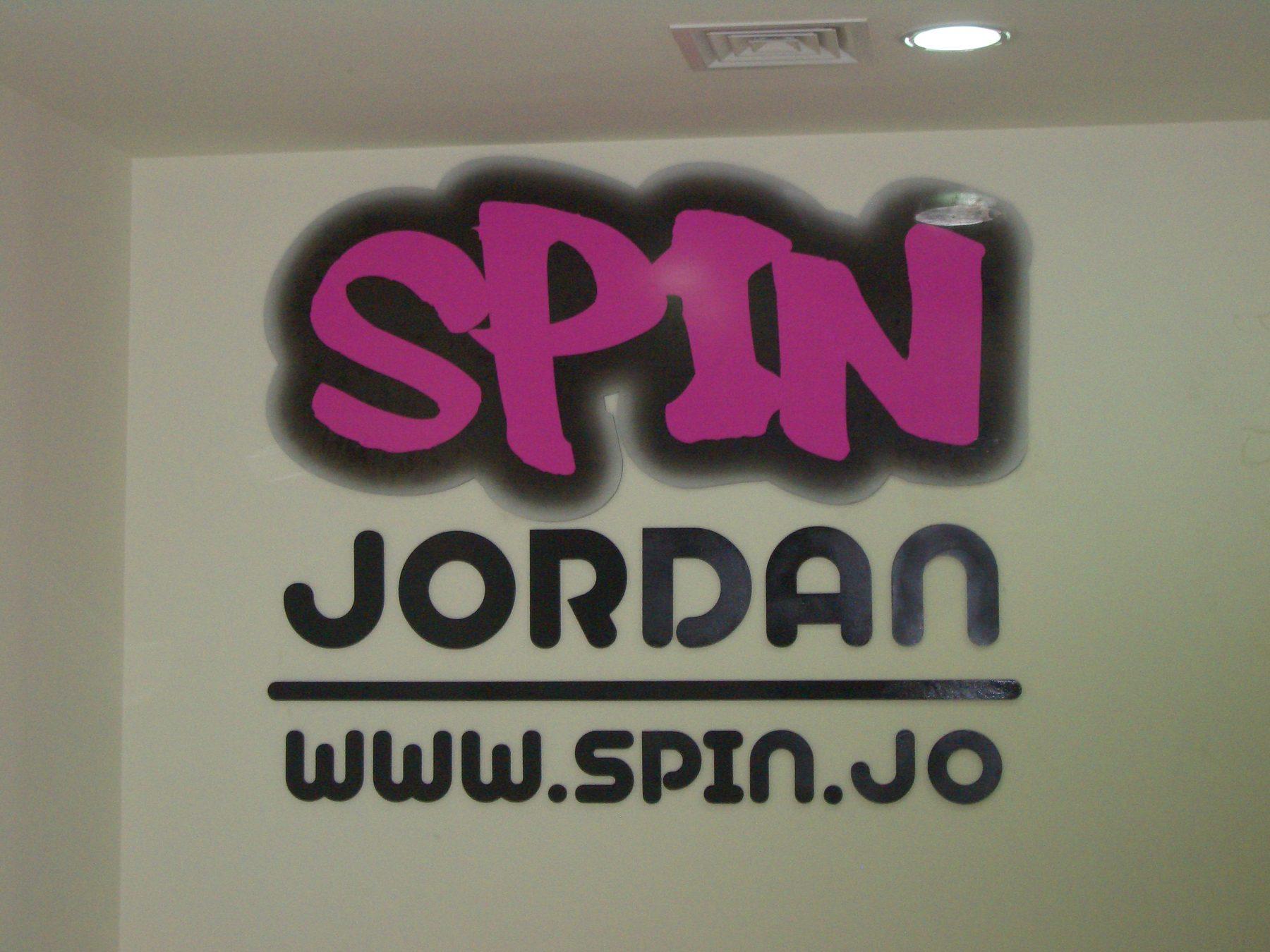 Logo lettering with web address on a pale wall