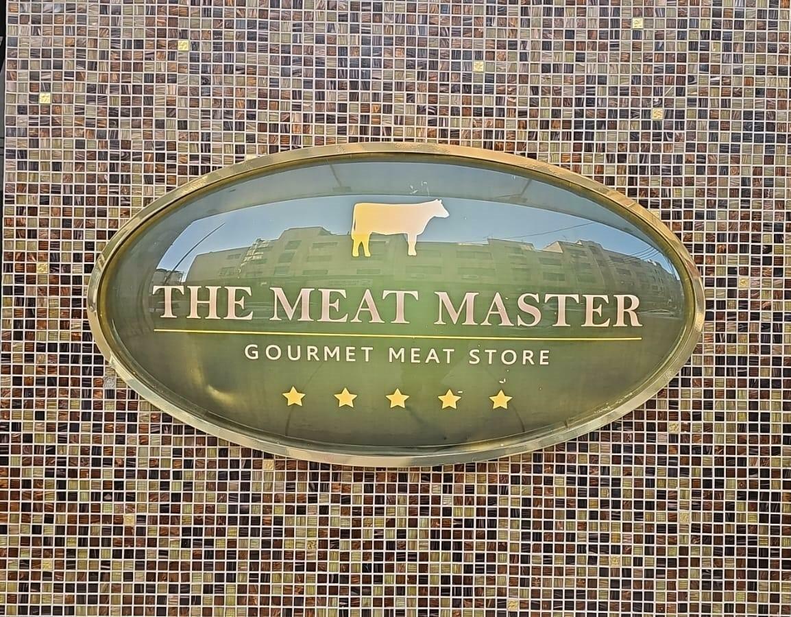 Gold oval fascia sign with a bull emblem and stars on a mosaic wall.