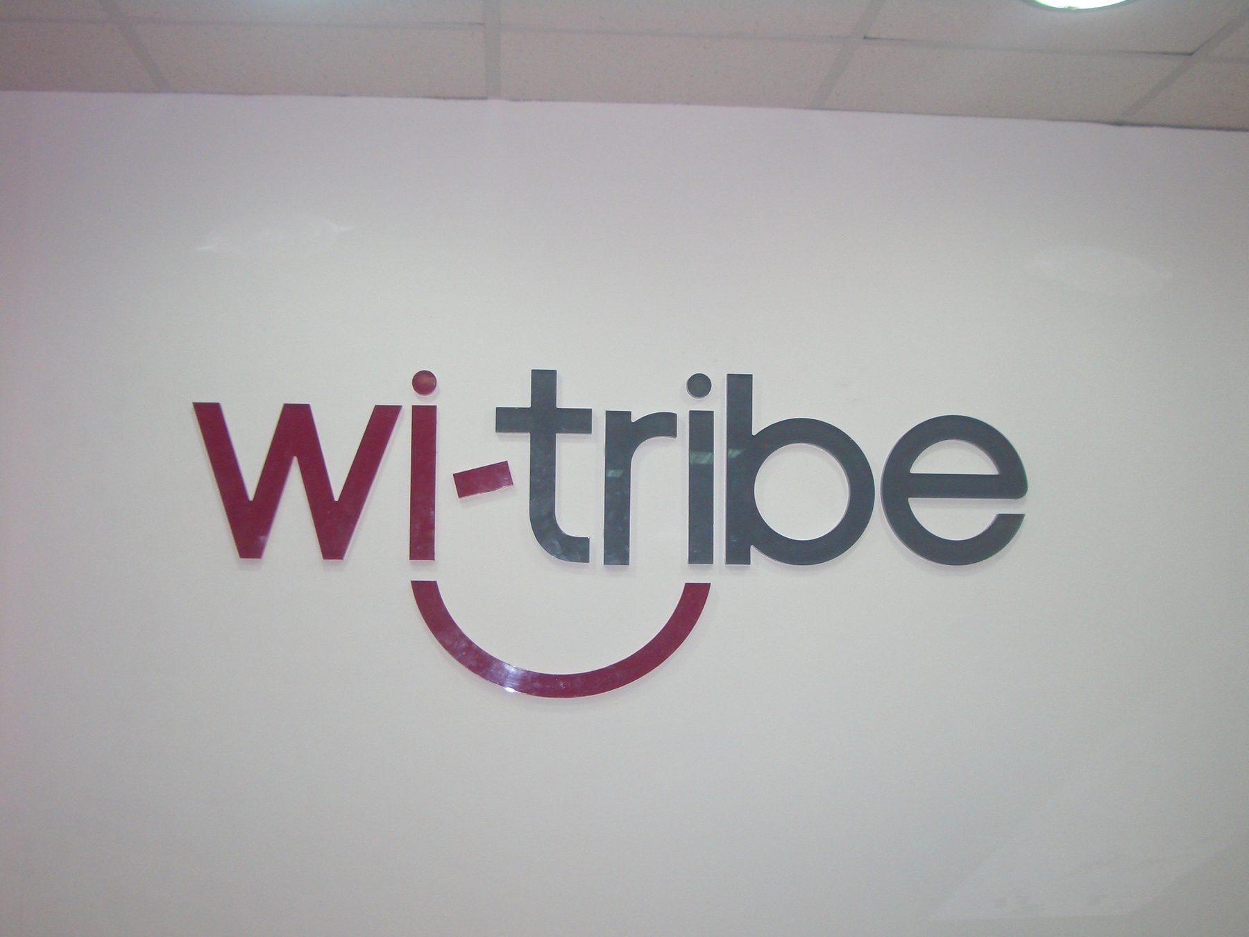 Dimensional logo with a red curved accent mounted on a white wall.