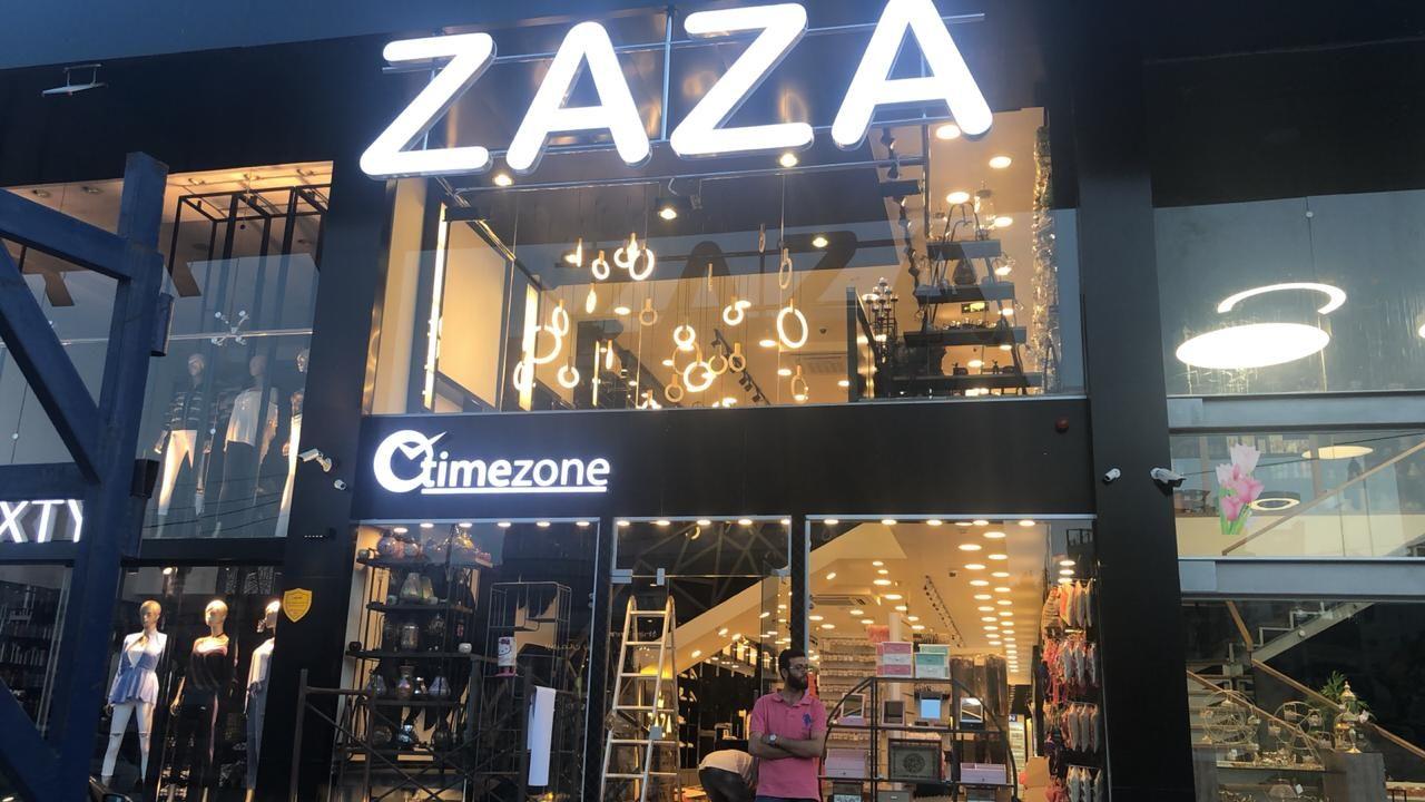 Lit fascia letters over a retail entrance at night