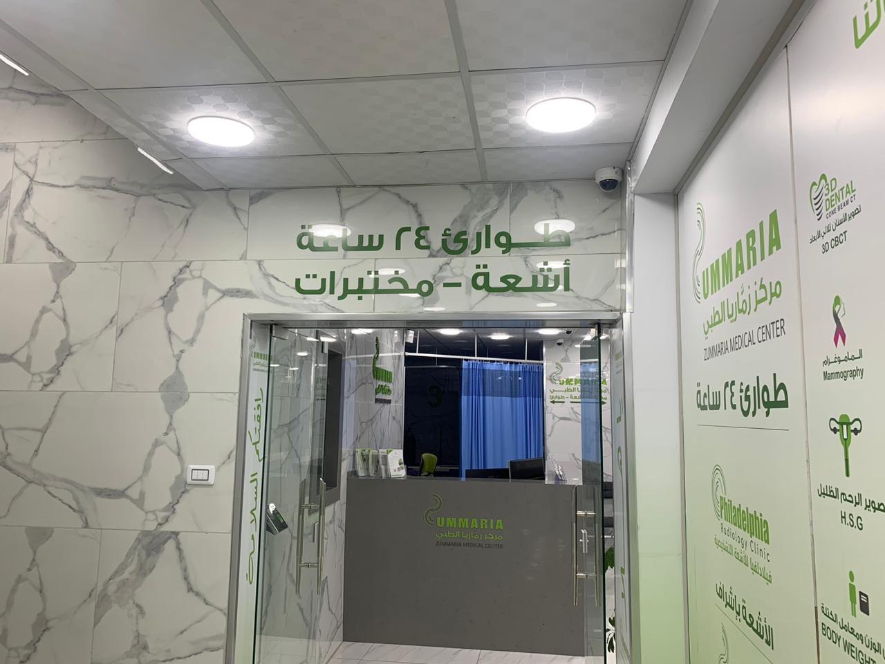 Entrance with green Arabic lettering for 24-hour emergency, X-ray and labs